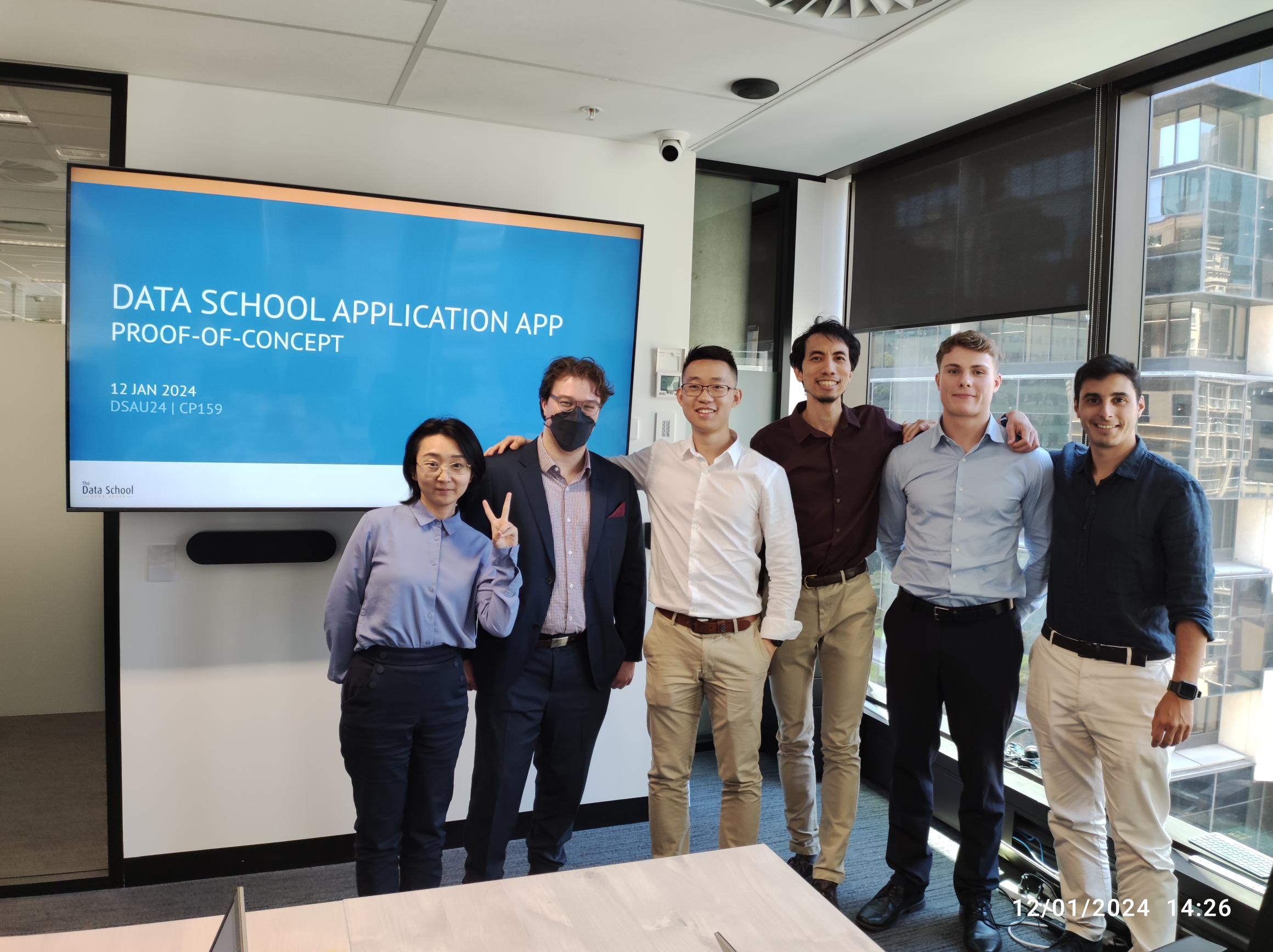 Picture of the project team, with everyone smiling next to a presentation slide
